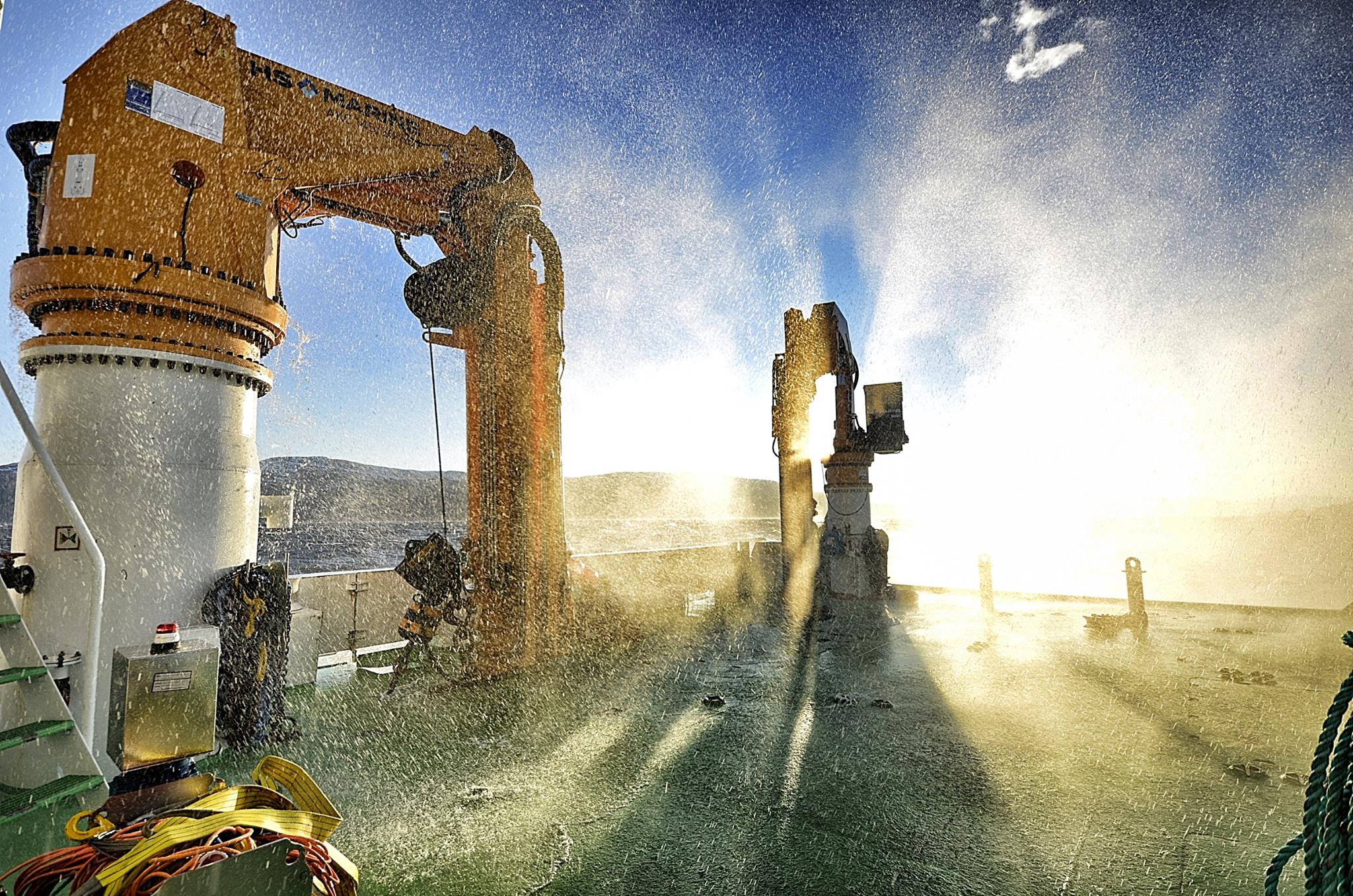 Multi-colored fishing nets raises the crane on the pier by the sea. Fish  production. Repair of networks Stock Photo